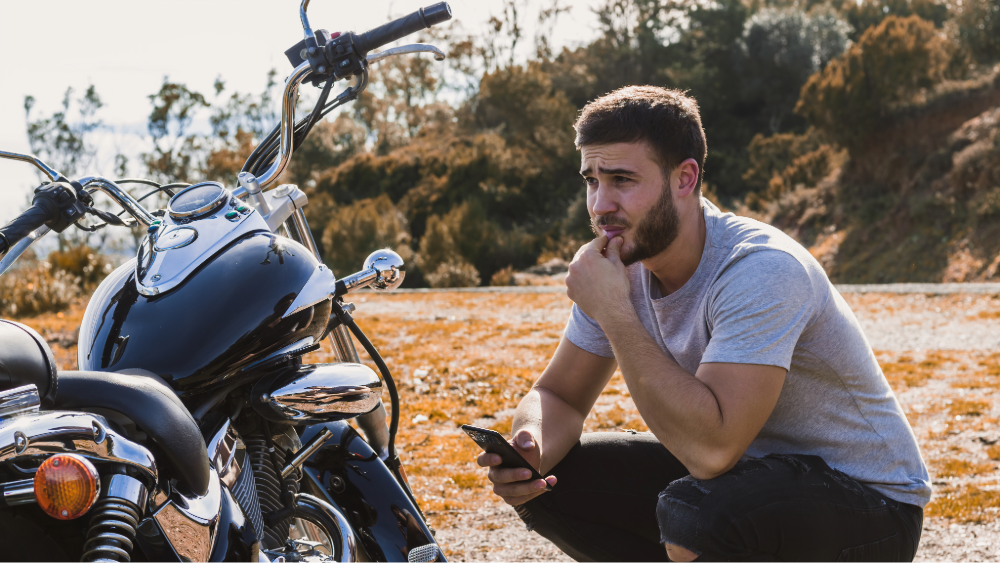 Motorcyclist stranded with a dead battery by the roadside