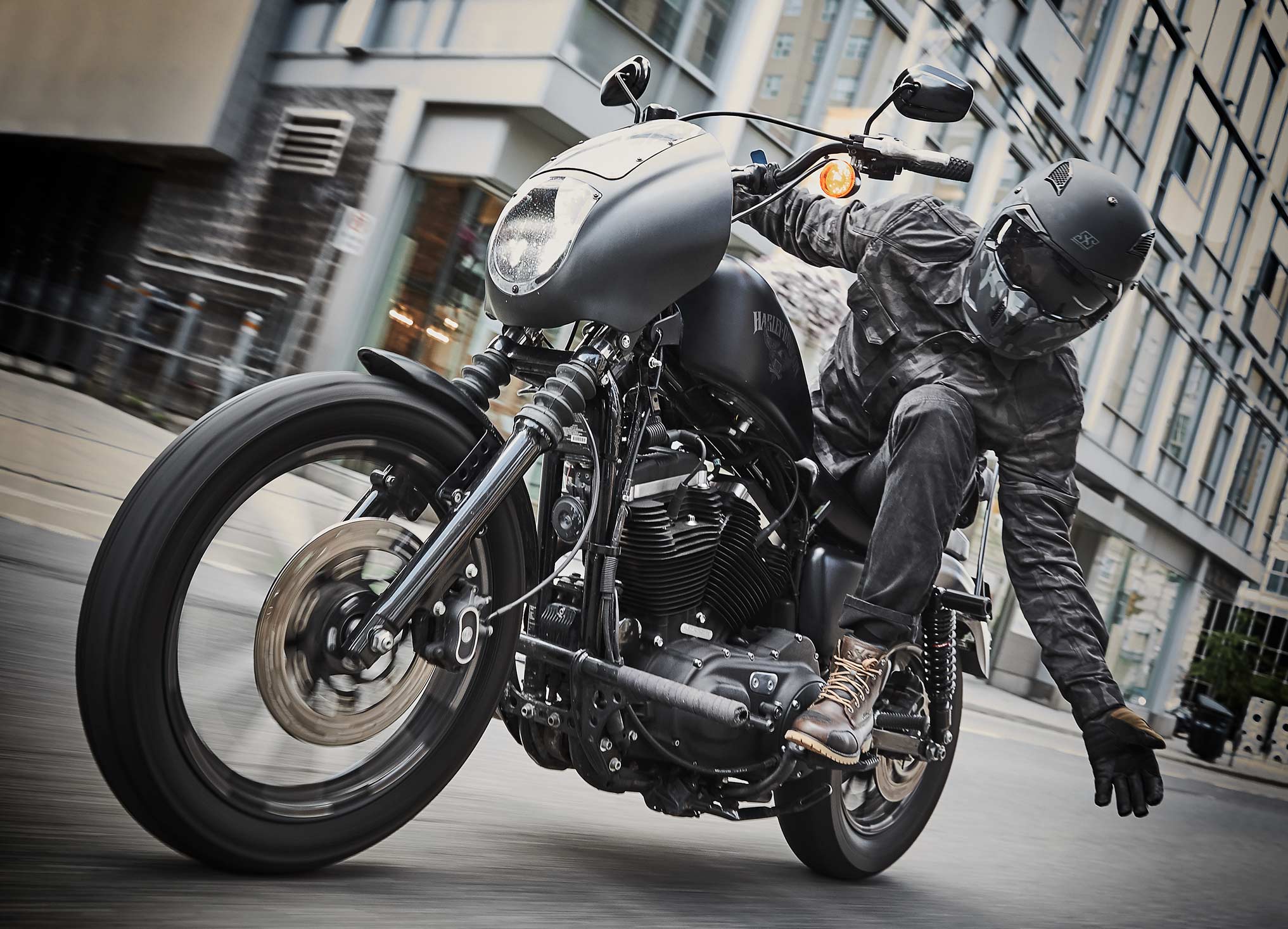 Rider in full gear leaning over to high-five camera