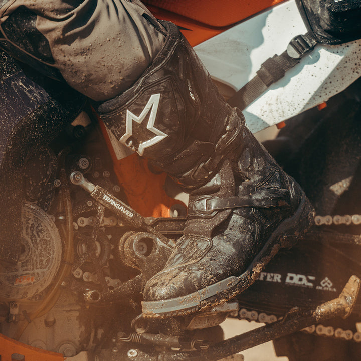 Alpinestars Corozal V2 Adventure Drystar Boots Black - Lifestyle Close-Up of Muddy Boot worn by rider
