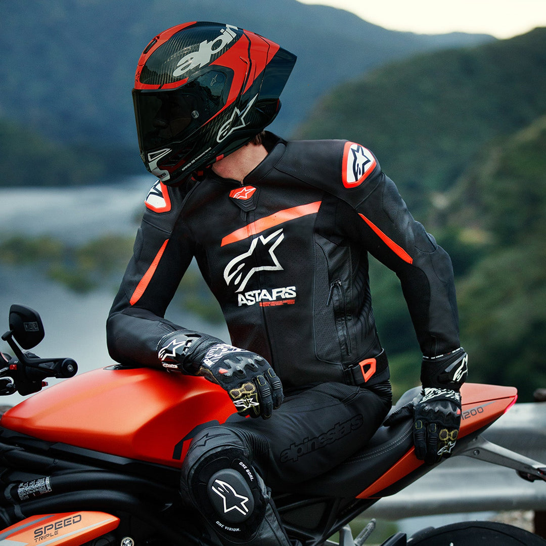 Alpinestars GP Plus R V4 Airflow Leather Jacket Black/Red Fluo/White - Lifestyle shot of rider in jacket on red motorcycle