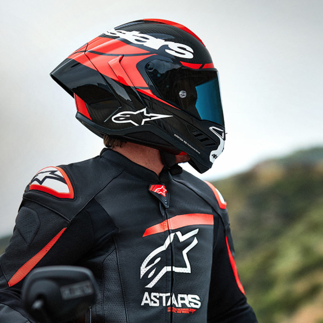 Alpinestars Supertech R10 Element Helmet Carbon/Red/White - lifestyle shot of rider wearing helmet, looking to the side