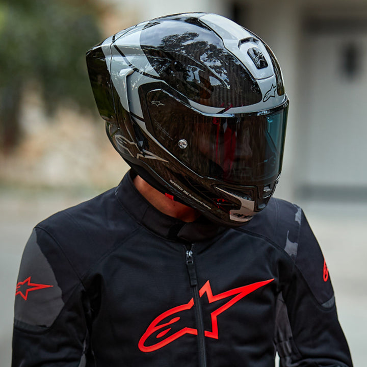 Alpinestars Supertech R10 Element Helmet Carbon/Silver/Black - Lifestyle shot of rider wearing helmet