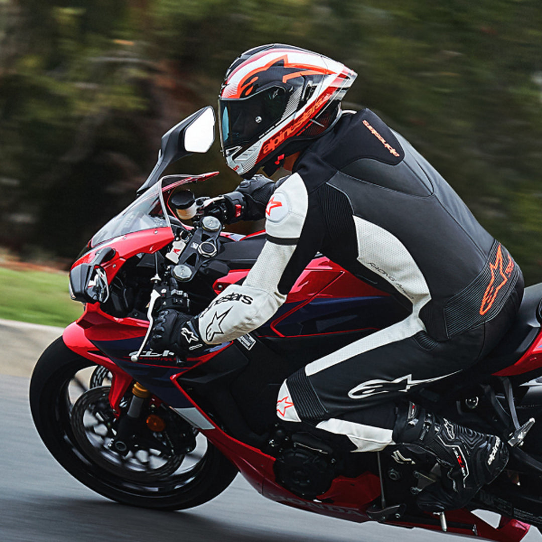 Alpinestars Supertech R10 Team Helmet Black/Carbon Red/Gloss White - Lifestyle shot of rider wearing helmet on red sport motorcycle