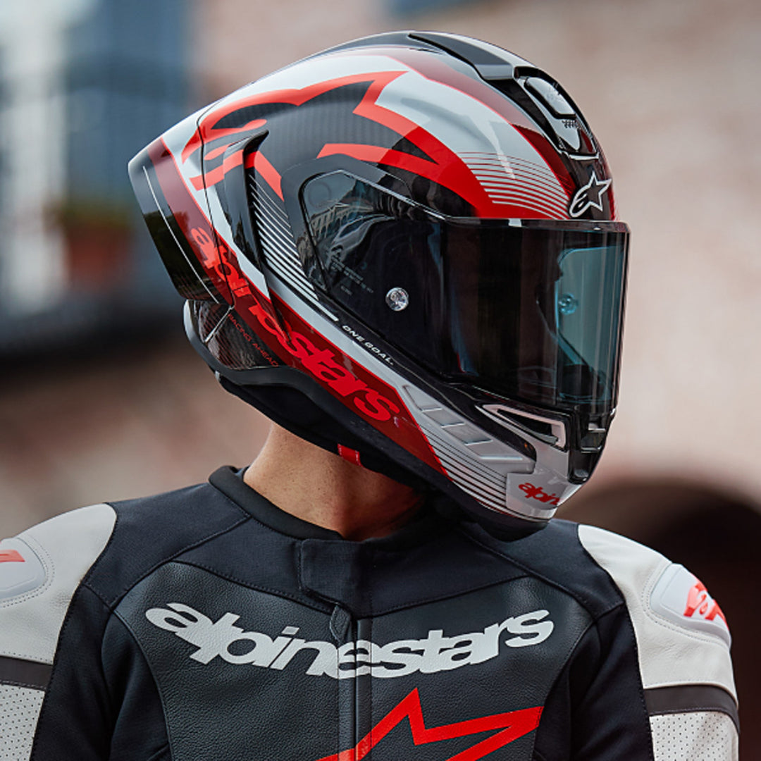 Alpinestars Supertech R10 Team Helmet Black/Carbon Red/Gloss White - lifestyle shot of rider wearing helmet, looking to the side