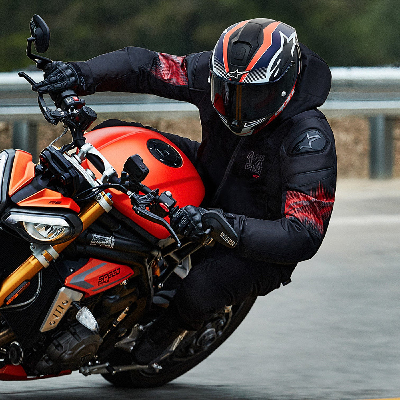 Alpinestars Zaca Air Venom WP Jacket Black/Bright Red - Lifestyle shot of rider wearing jacket coming through turn on red motorcycle