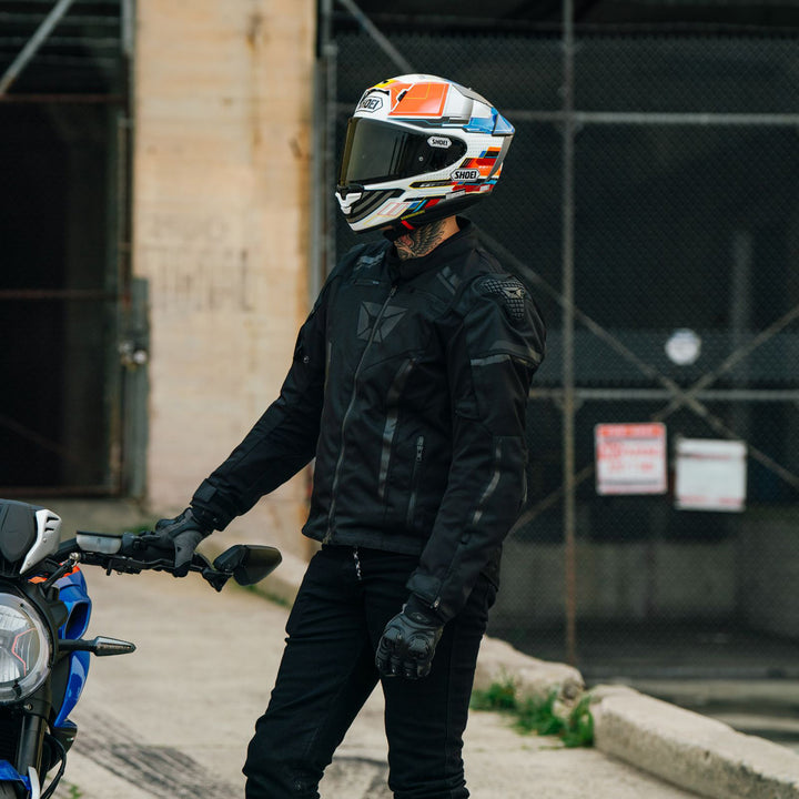 Cortech Men's Hyper-Tec 2.0 Jacket Black - Lifestyle shot of rider wearing jacket and standing next to parked motorcycle