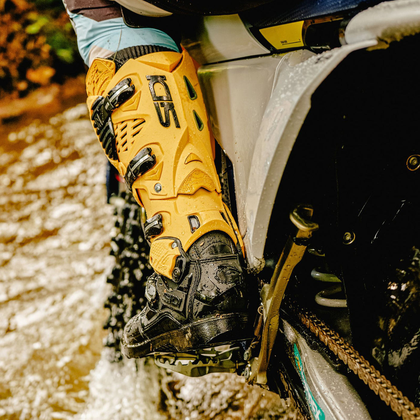 Sidi Crossfire 3 TA Boot Gold/Black - Lifestyle Close-up of Boot Worn by Rider on Dirt Bike Going Through Creek