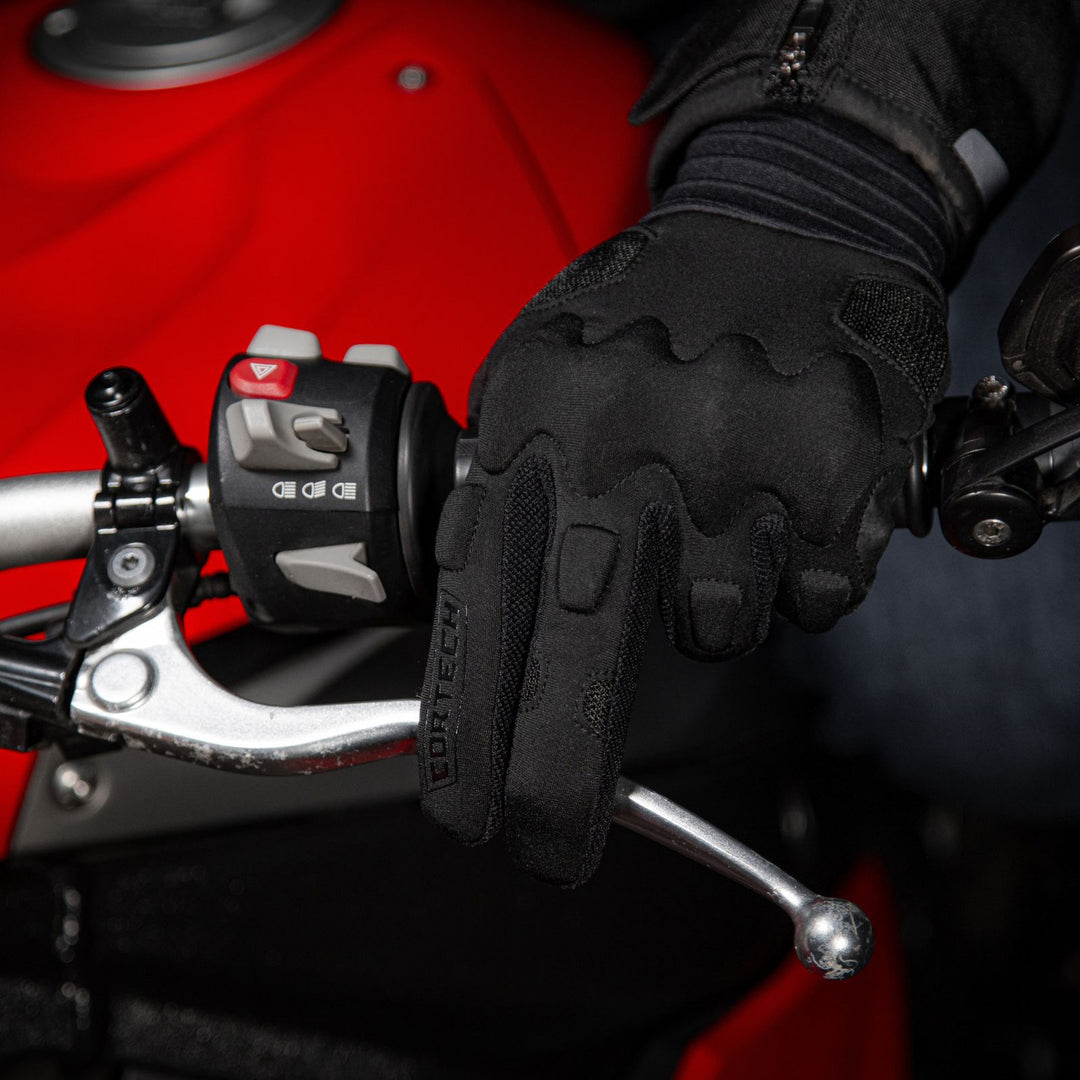 Cortech Lite Gloves Black/Black - Lifestyle Close-Up of gloved hand gripping motorcycle grip with two fingers on clutch lever