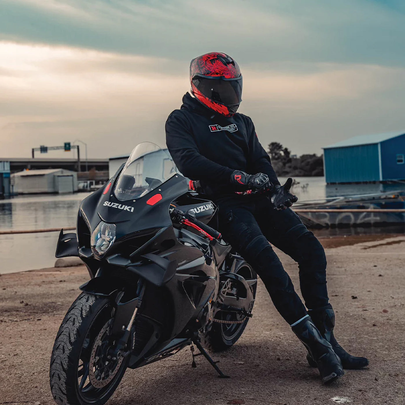 Daytona Helmets D.O.T. Detour Helmet - Havoc - Lifestyle Shot of Rider in helmet leaning on black sport motorcycle