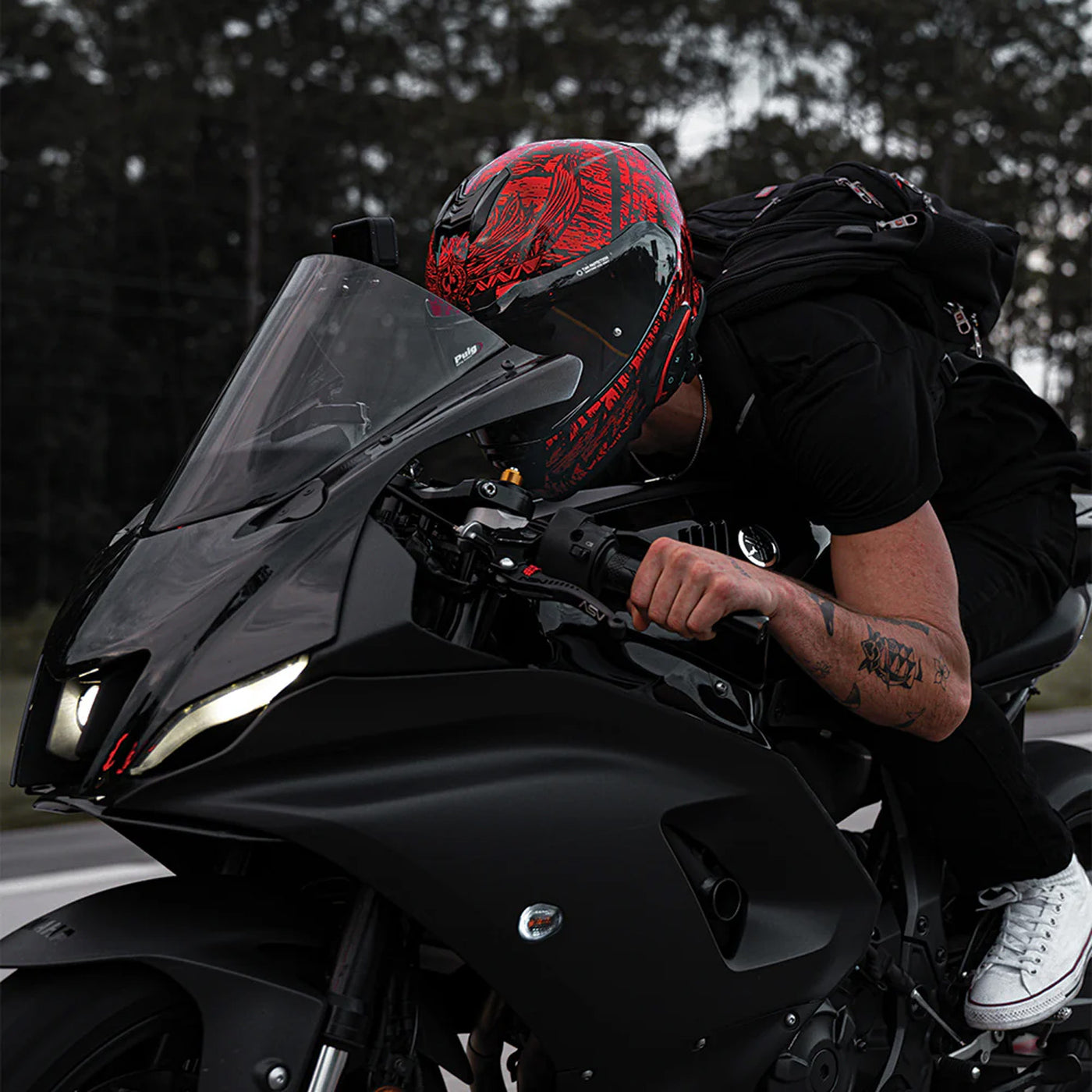 Daytona Helmets D.O.T. Detour Helmet - Havoc - Lifestyle shot of rider in helmet tucked in while riding black sport motorcycle