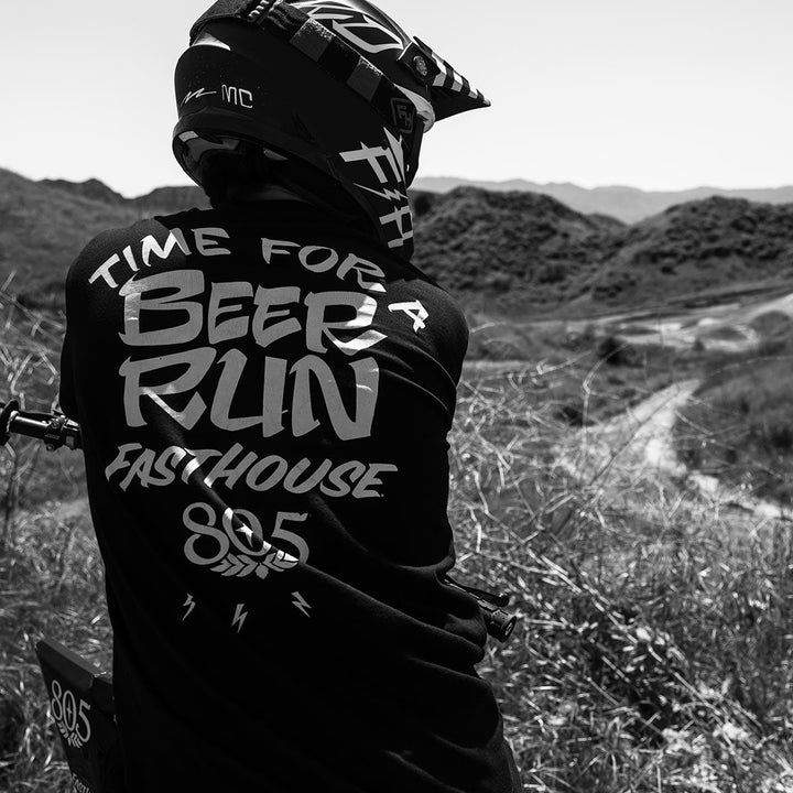 Fasthouse 805 Beer Run Tee Black - Lifestyle Shot of Rider wearing shirt looking over valley