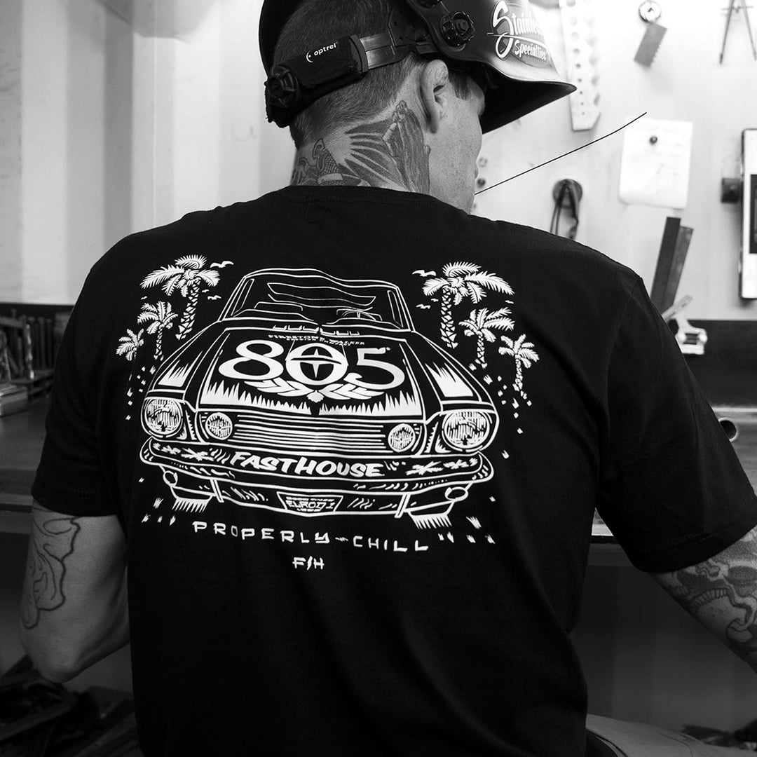 Fasthouse 805 Sunset Tee Black - Lifestyle shot of Man wearing shirt in garage