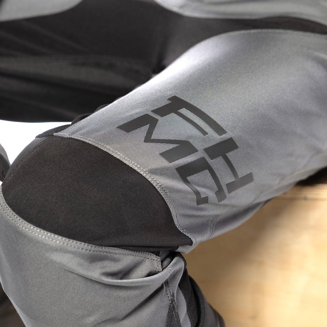 Fasthouse Carbon Method Pants Gray/Black - Close-Up of Knee Details and Lower Left Thigh Graphics