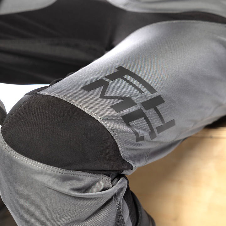 Fasthouse Carbon Method Pants Gray/Black - Close-Up of Knee Details and Lower Left Thigh Graphics