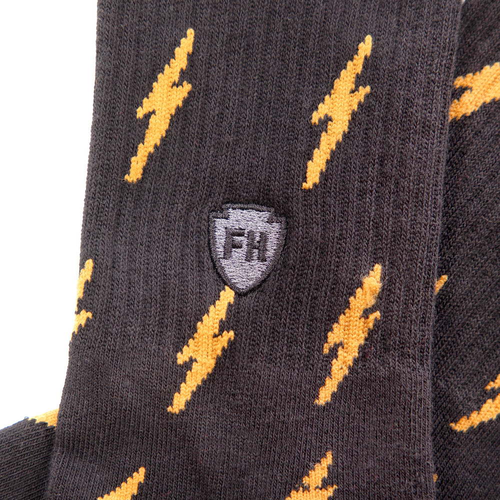 Fasthouse Circuit Crew Socks Black/Vintage Gold - Close-Up Side View of Stitched Logo