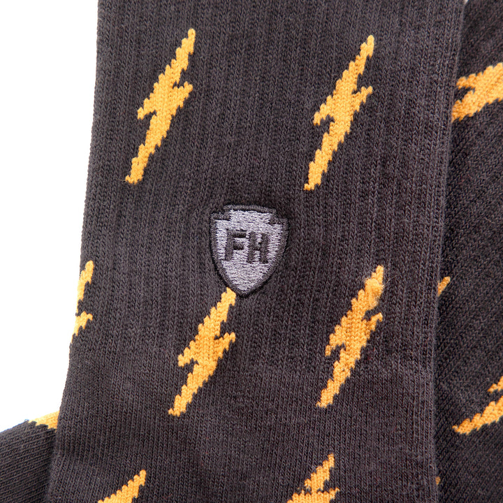 Fasthouse Circuit Crew Socks Black/Vintage Gold - Close-Up Side View of Stitched Logo