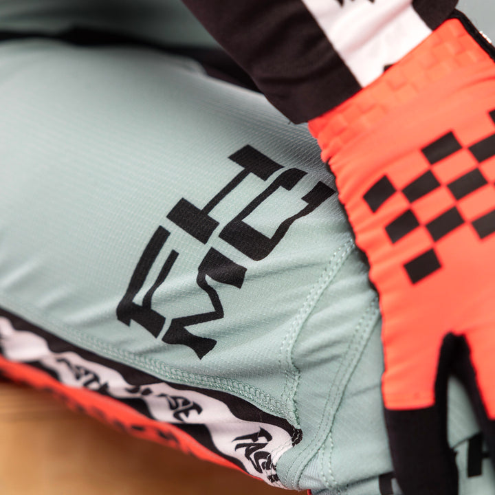 Fasthouse Elrod Formula Pants Oceanic Mint/Hyper Coral - Close-Up of Lower Right Thigh Graphics