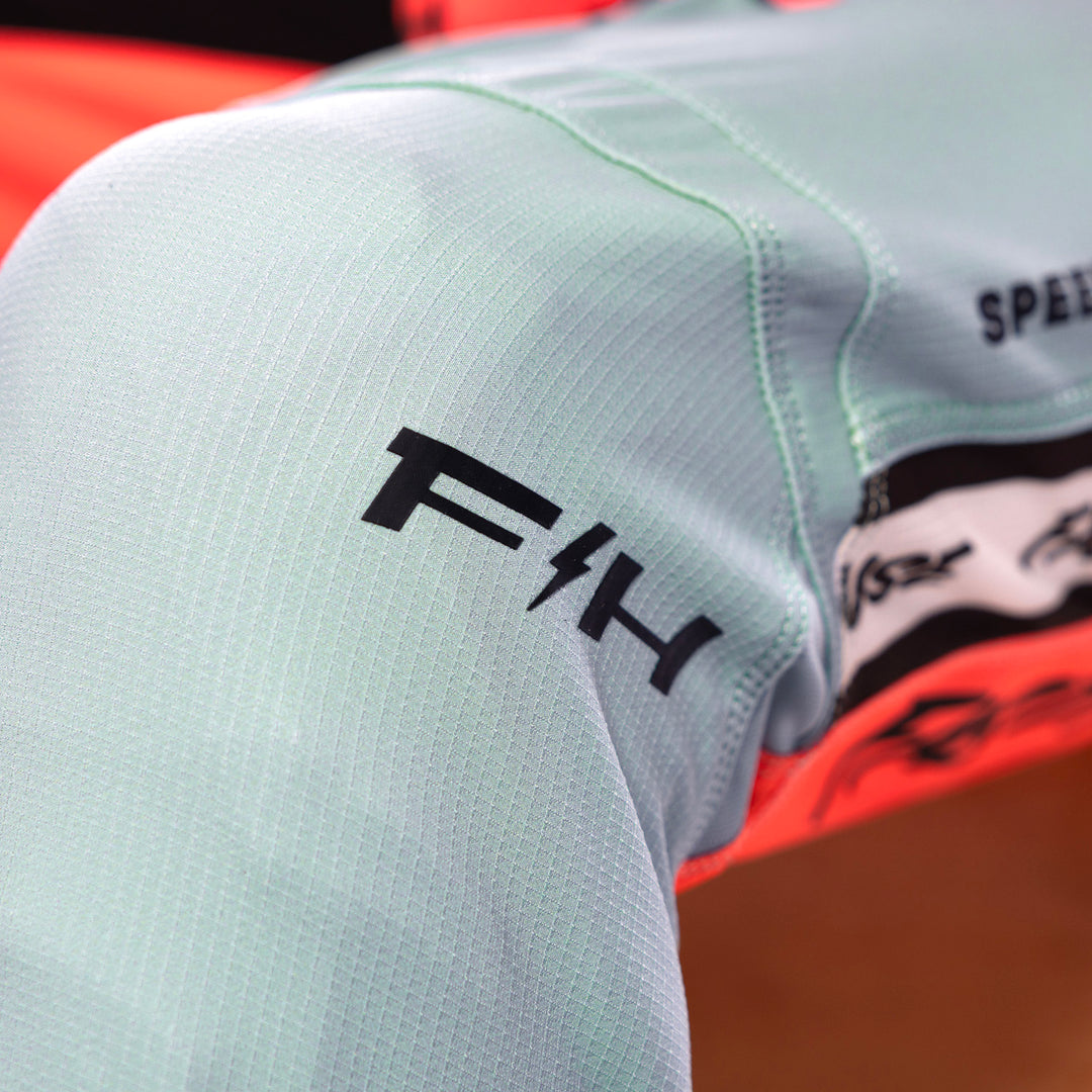 Fasthouse Elrod Formula Pants Oceanic Mint/Hyper Coral - Close-Up of Left Knee Graphics