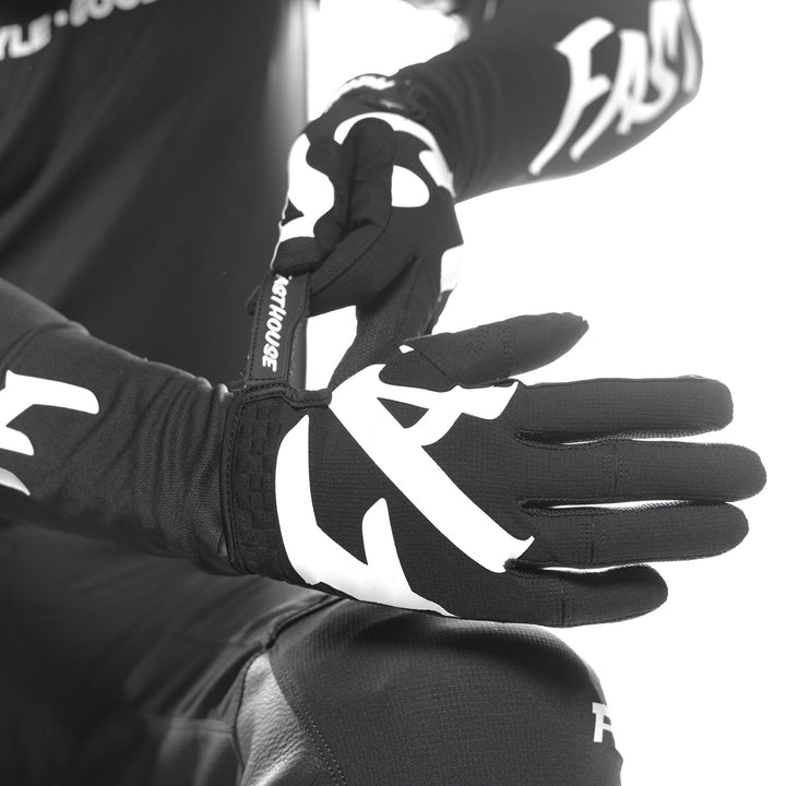 Fasthouse Elrod Torque Gloves Black - Close-Up of Model Wearing Gloves, Adjusting Strap on Right Hand
