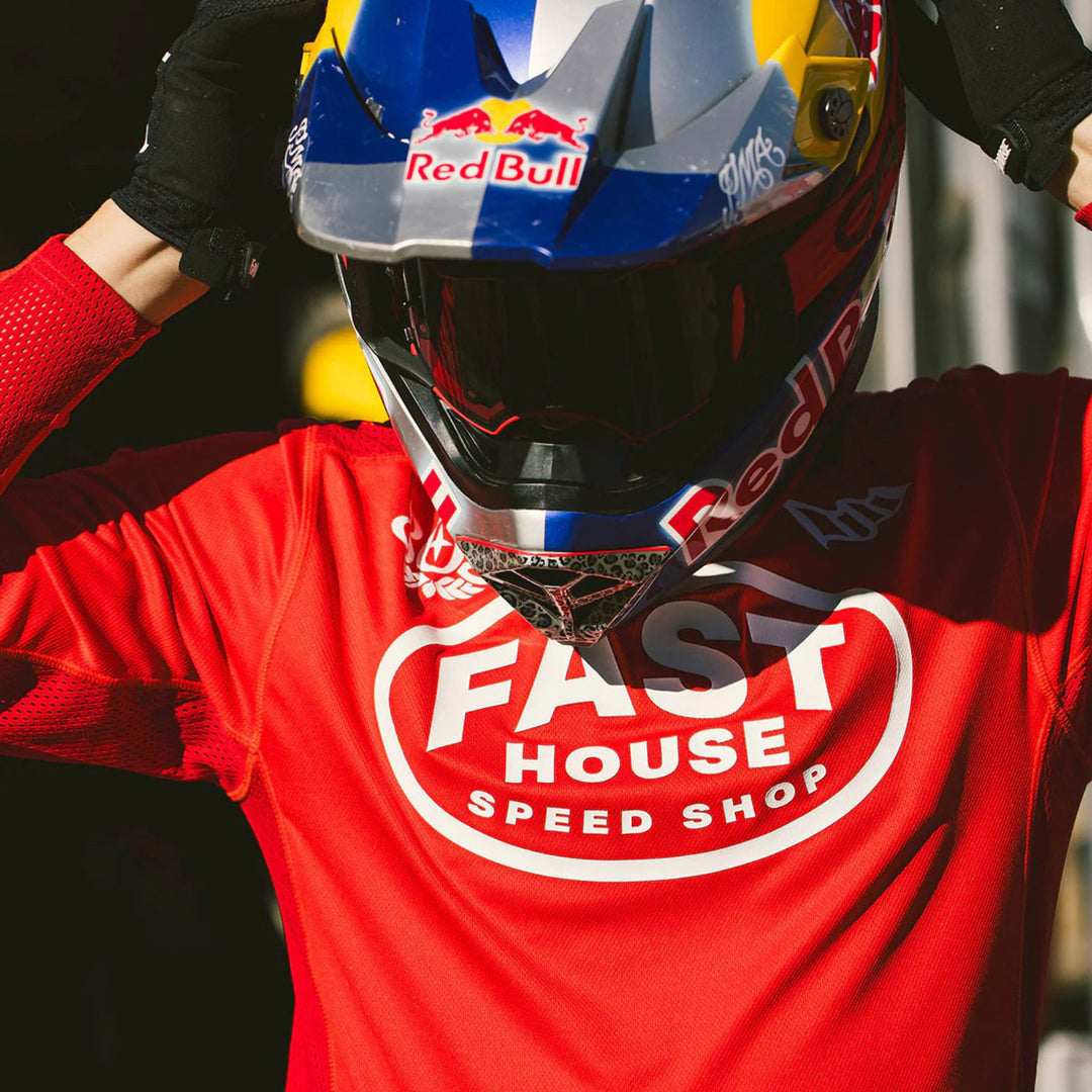 Fasthouse Grindhouse Air-Cooled Ramble Jersey Red - Lifestyle Shot of Rider Wearing Jersey while Adjusting Goggles