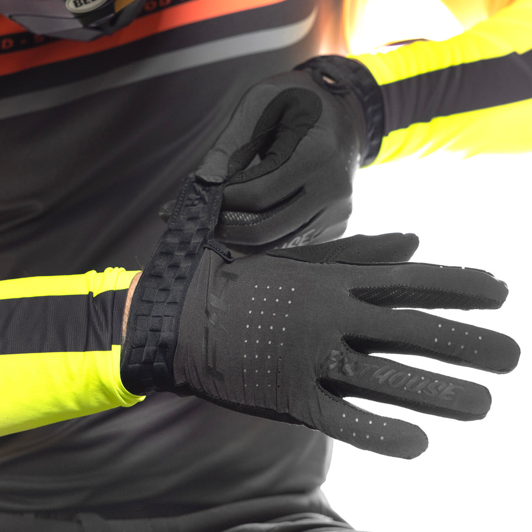Fasthouse Helix Circuit Gloves Black - Close-Up of Model Wearing Gloves, Adjusting Strap on Right Hand