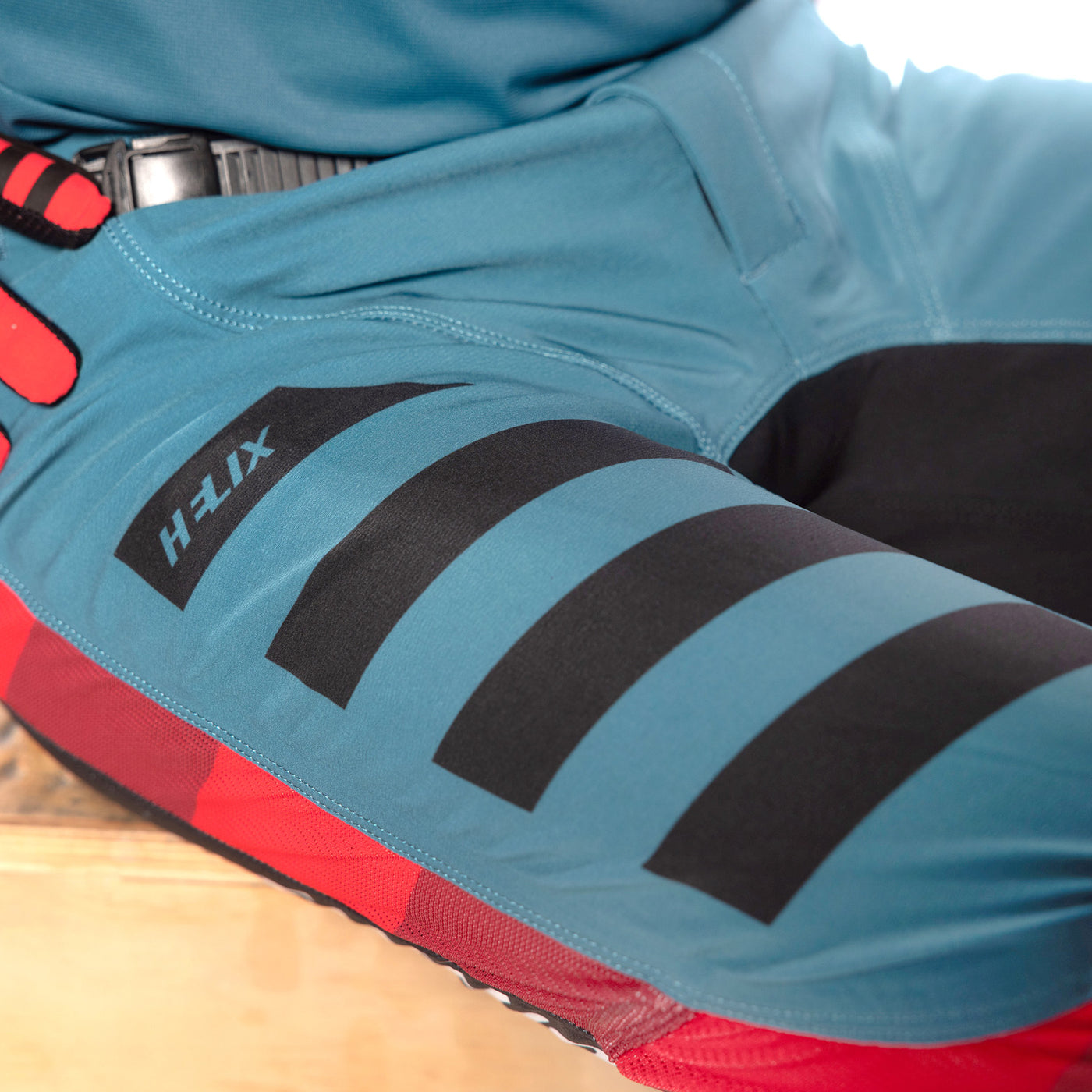 Fasthouse Helix Podium Pant Red/Black/Teal - Close-Up of Front Right Thigh Graphic