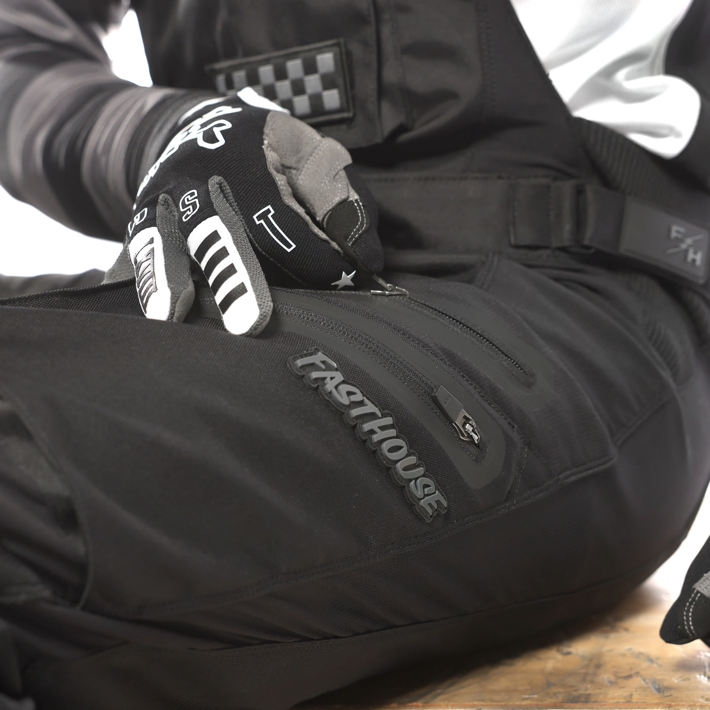 Fasthouse Motorall MX Black - Close-Up of Model Unzipping Thigh Pocket