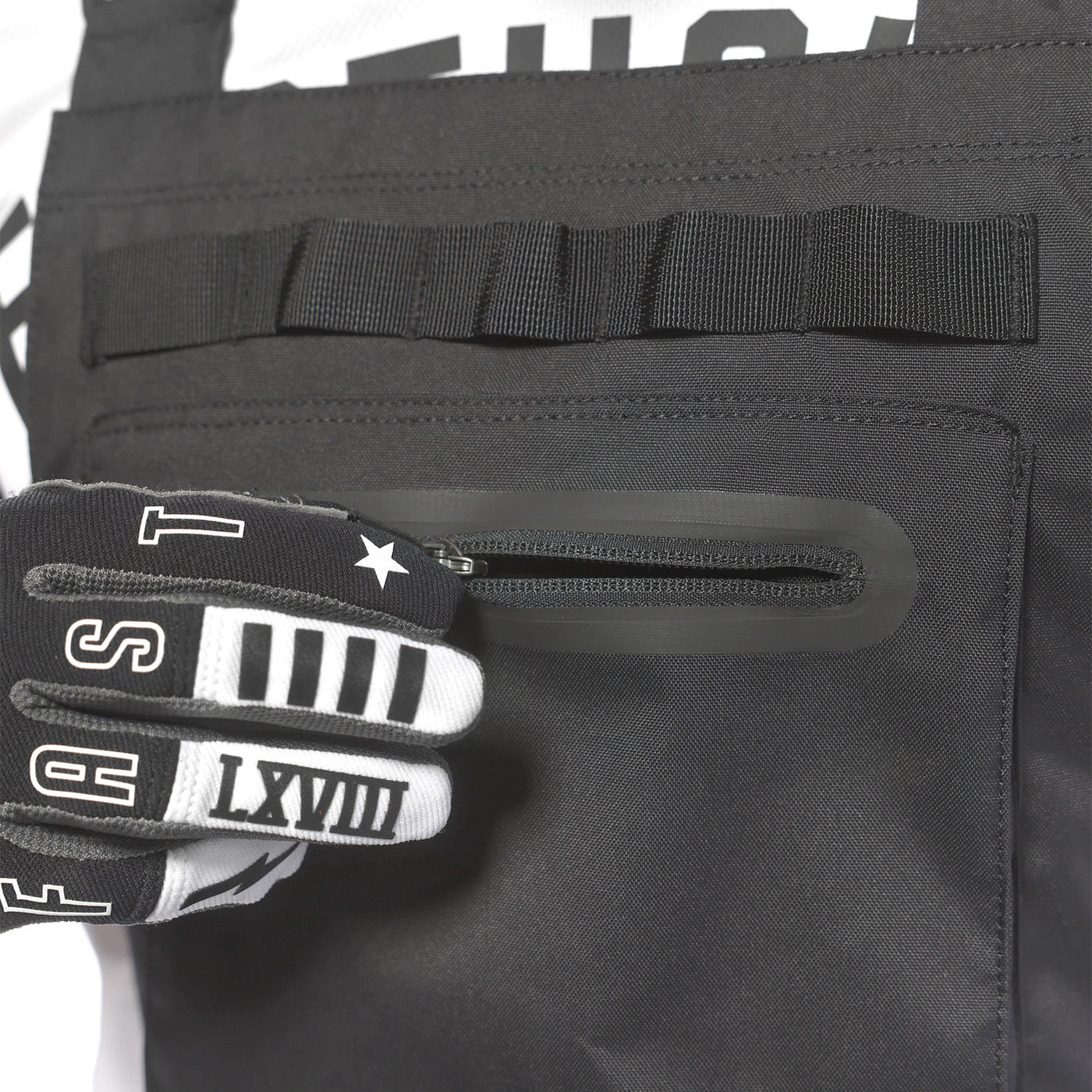 Fasthouse Motorall MX Black - CLose-Up of Model Unzipping Front Pocket