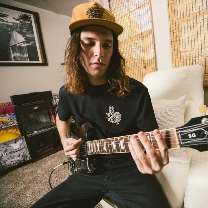 Fasthouse Satisfaction SS Tee Black - Lifestyle of Man Wearing Shirt while Playing Guitar