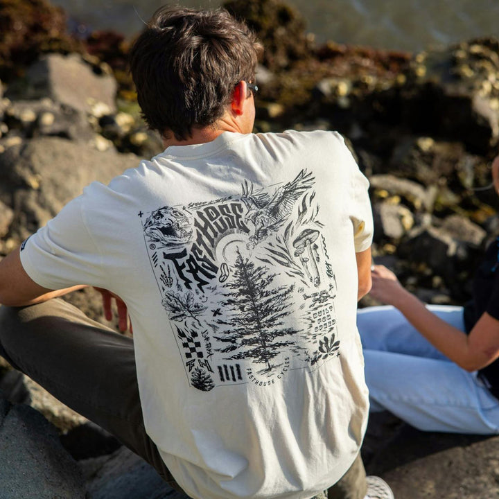 Fasthouse Tomahawk SS Tee Natural - Lifestyle Rear View of Man Wearing Shirt sitting on rocky slope