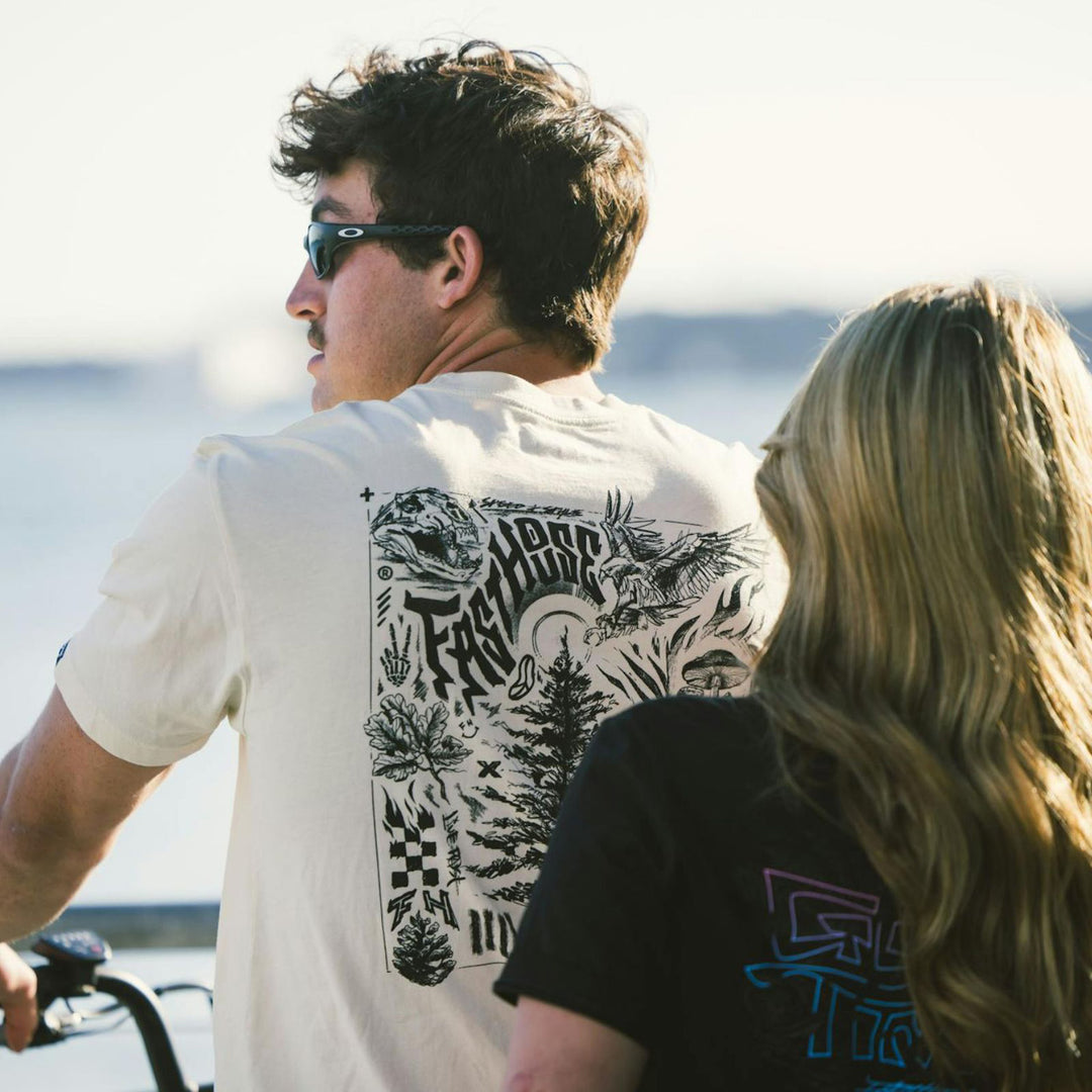 Fasthouse Tomahawk SS Tee Natural - Lifestyle Rear View of Man Wearing Shirt while riding bicycle