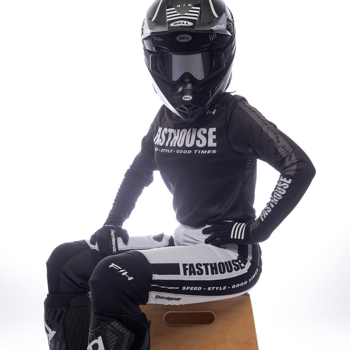 Fasthouse Women's Elrod Storm Jersey Black - Front Side View of Model Sitting While Wearing Jersey