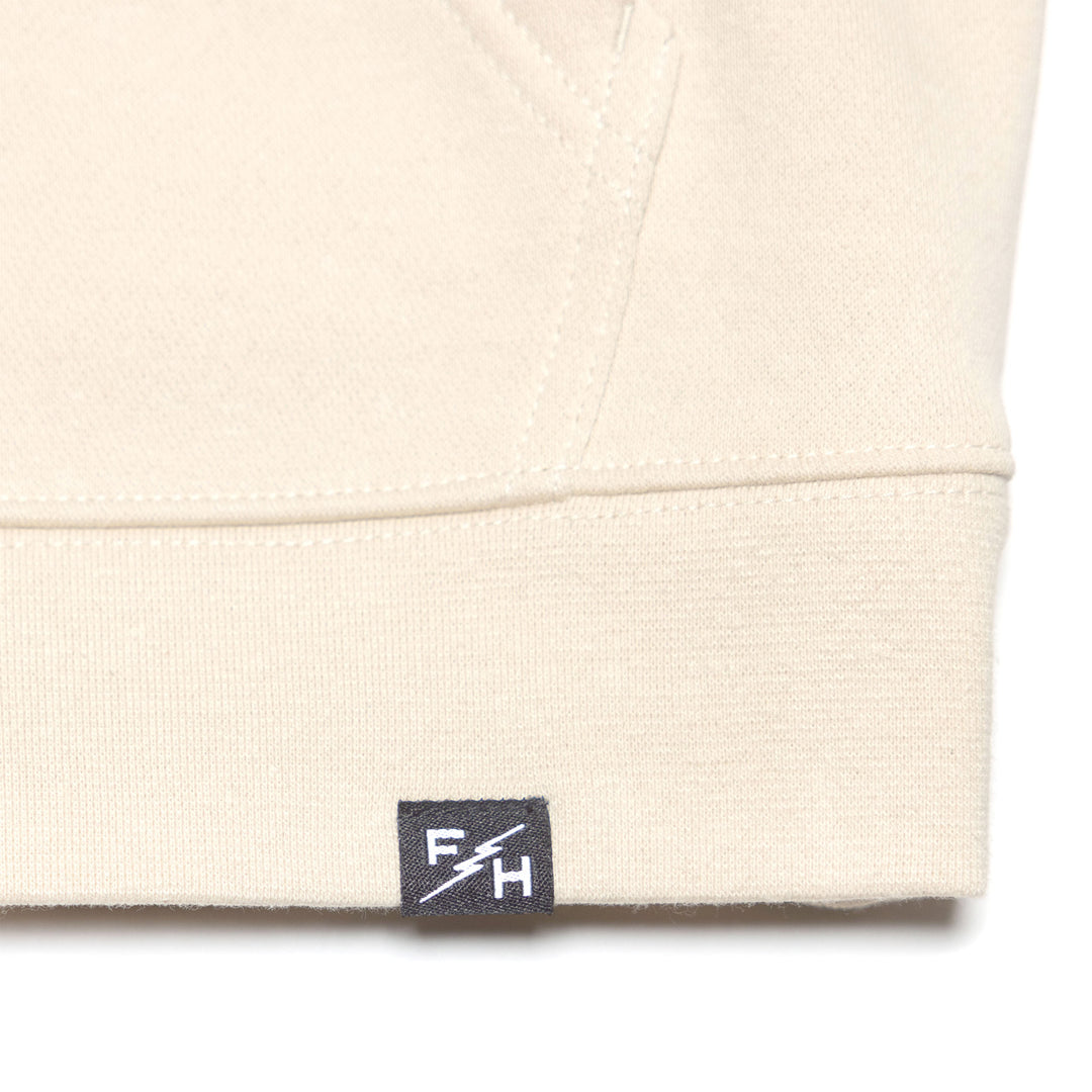 Fasthouse Women's Garden Party Hooded Zip-Up Chalk - Close-Up of Brand Tag on Hem