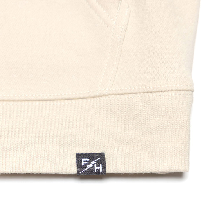 Fasthouse Women's Garden Party Hooded Zip-Up Chalk - Close-Up of Brand Tag on Hem
