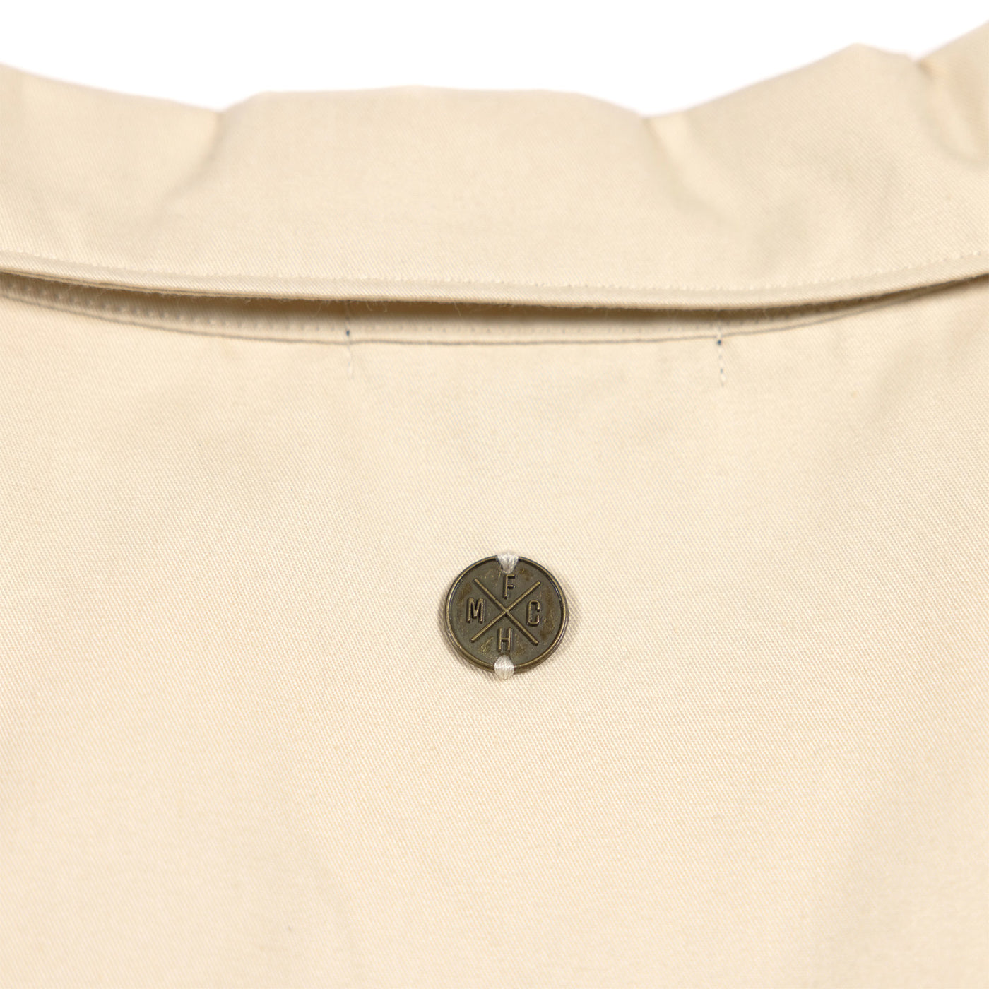 Fasthouse Women's Smoke Show Crop Button-Up Shirt Cream - Close-up of Metallic Logo on Back of Collar