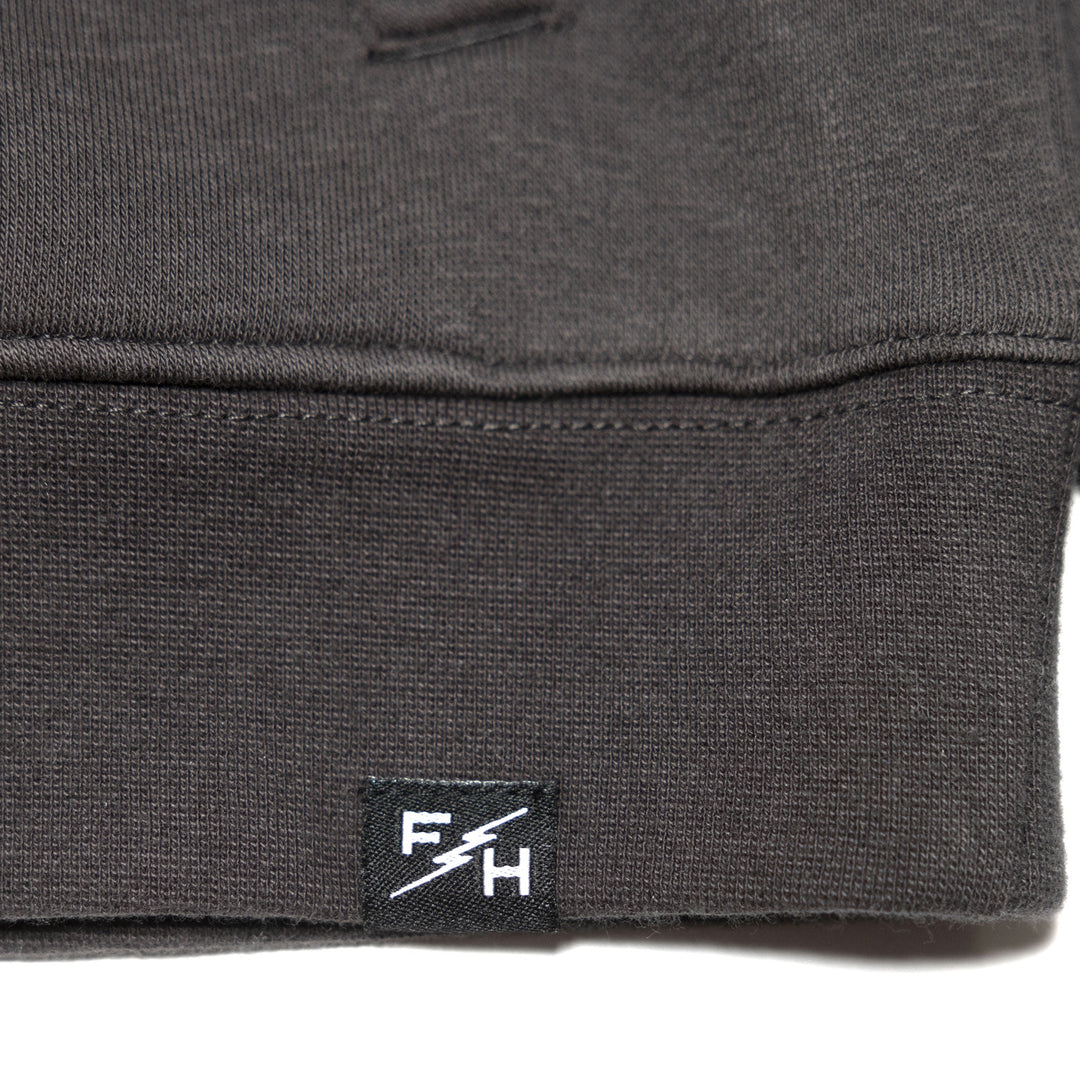 Fasthouse Women's Sun Struck Hooded Pullover Black - Close-Up of Brand Tag on Hem