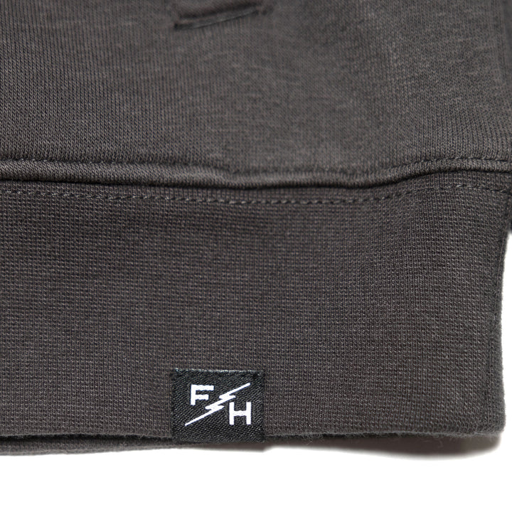 Fasthouse Women's Sun Struck Hooded Pullover Black - Close-Up of Brand Tag on Hem