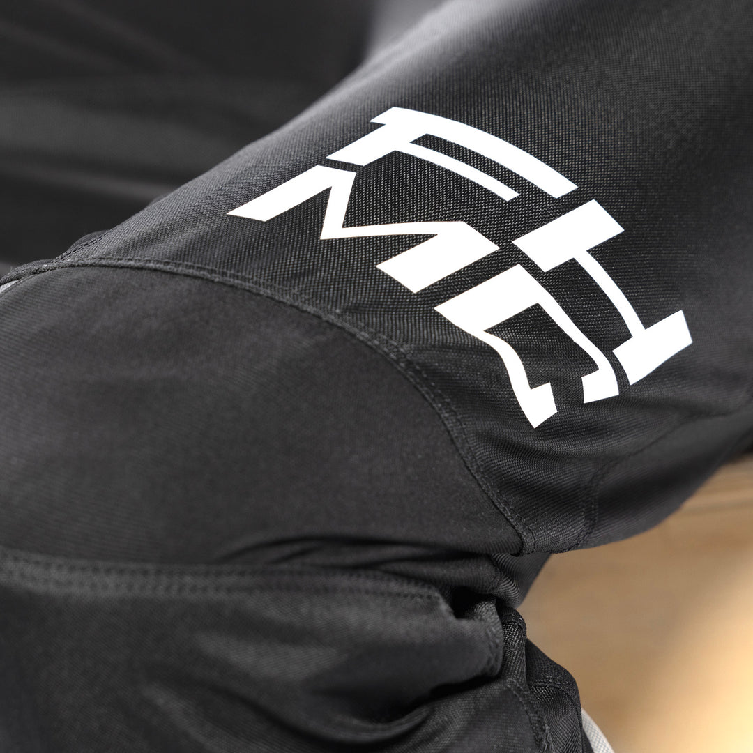 Fasthouse Youth Carbon Method Pants Black - Close-Up of Knee Details and Lower Left Thigh Graphics