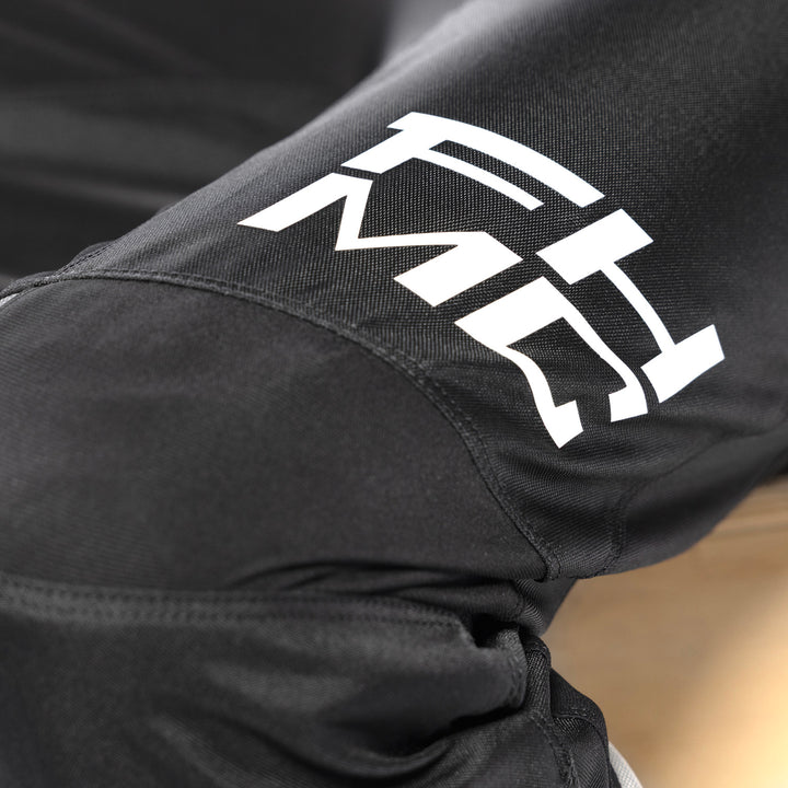 Fasthouse Youth Carbon Method Pants Black - Close-Up of Knee Details and Lower Left Thigh Graphics