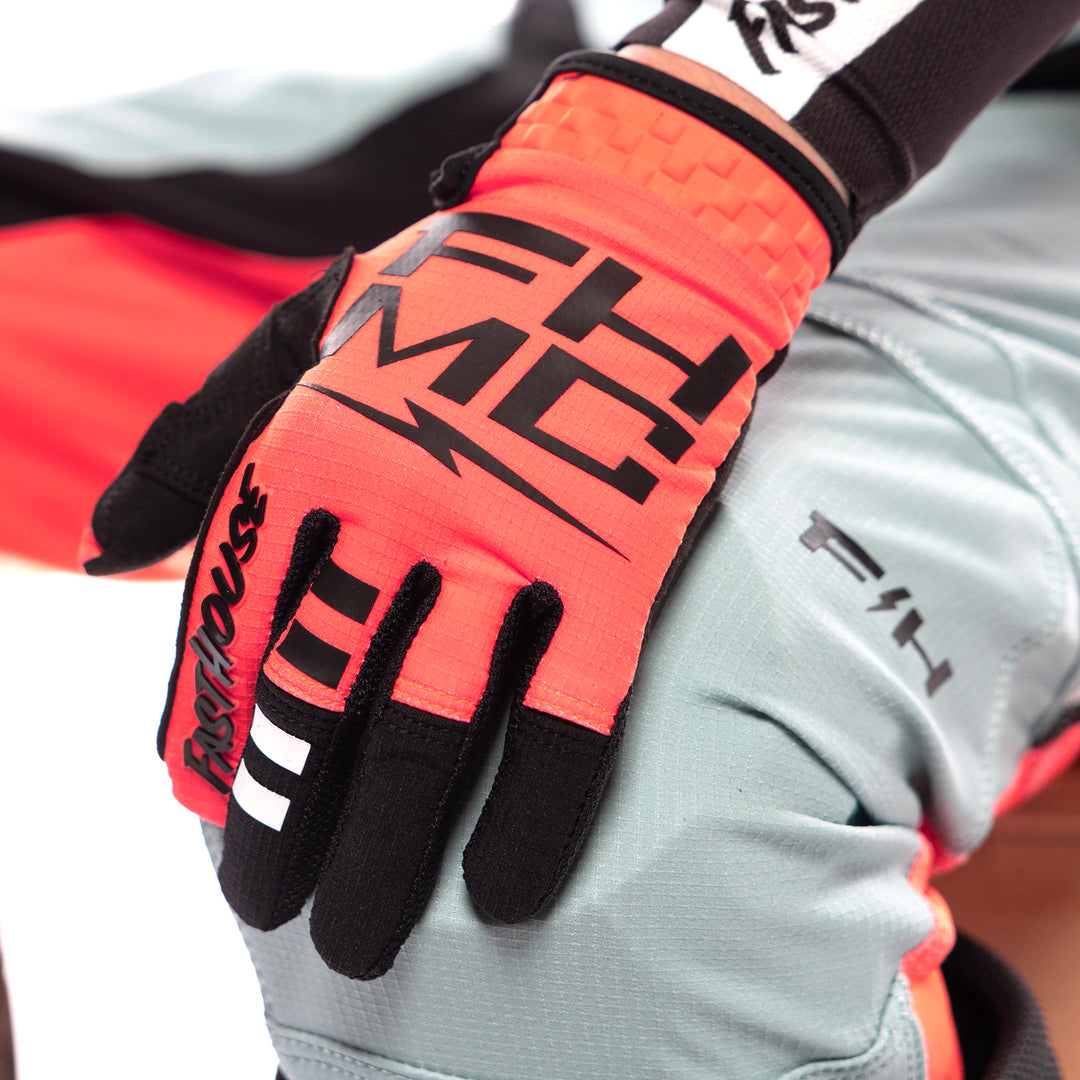 Fasthouse Youth Elrod Formula Gloves Hyper Coral - Close-Up of Model Wearing Gloves, Left Hand Resting on Left Knee
