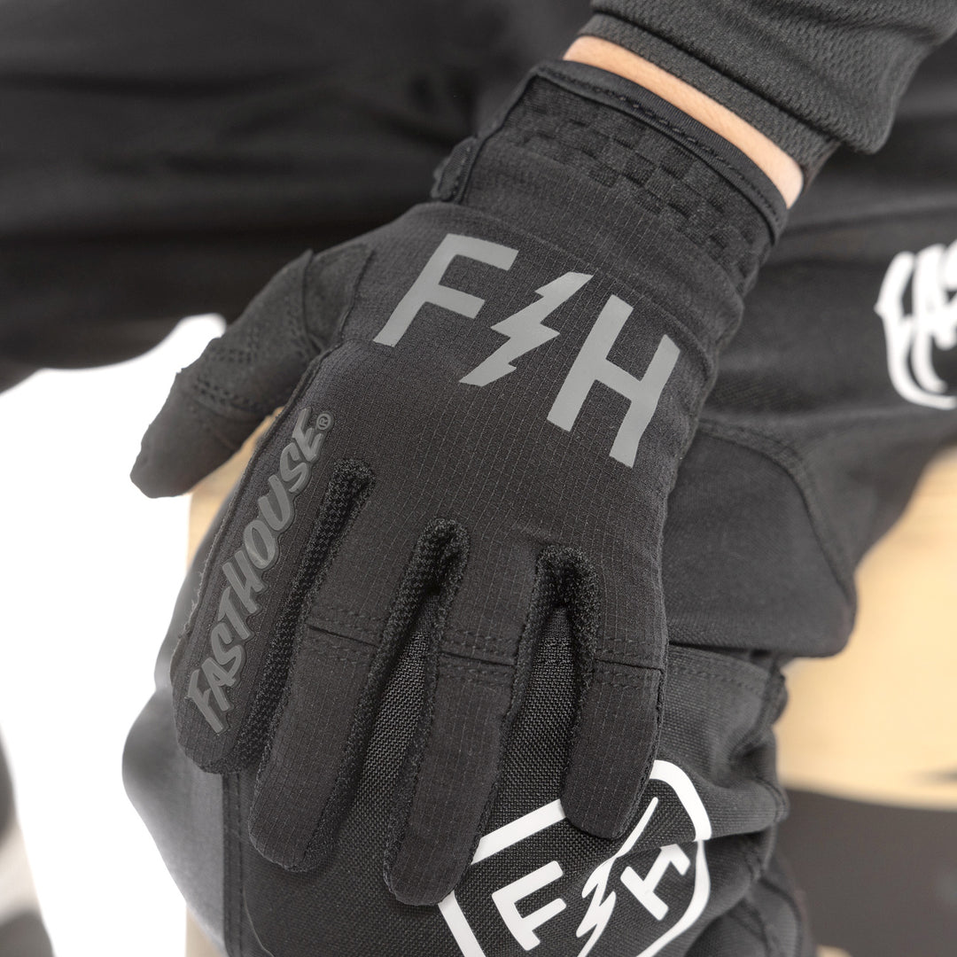 Fasthouse Youth Speed Style Akin Gloves Black/Gray - Close-Up of Left Gloved Hand Resting on Knee