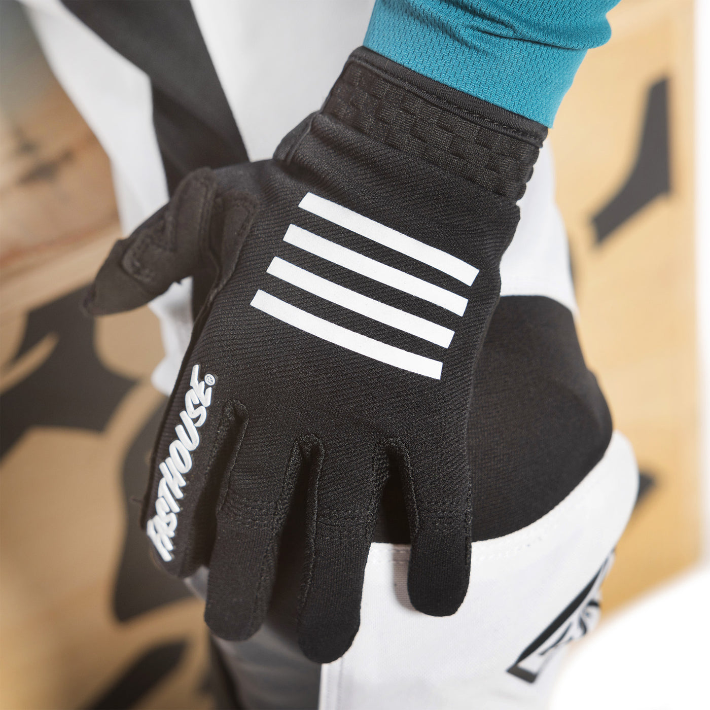 Fasthouse Youth Speed Style Grit Gloves Black - Close-Up of Left Gloved Hand Resting on Knee