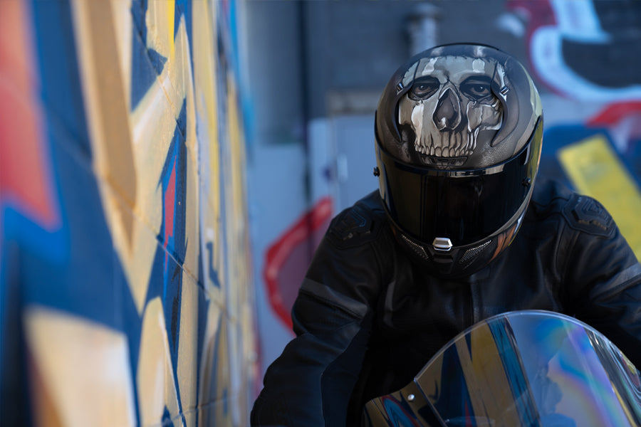 Rider wearing Call of Duty Ghosts HJC Helmet parking next to graffiti wall