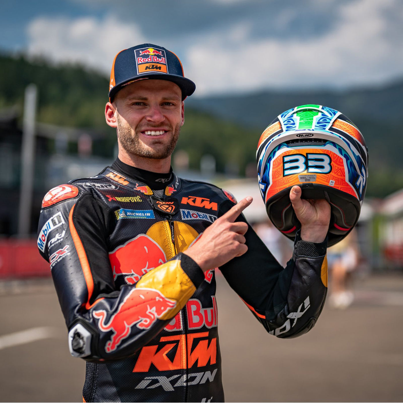 HJC RPHA 1N Brad Binder Helmet MC-27SF - Lifestyle Shot of Brad Binder Holding up Helmet and Pointing at 33 Printed on Back