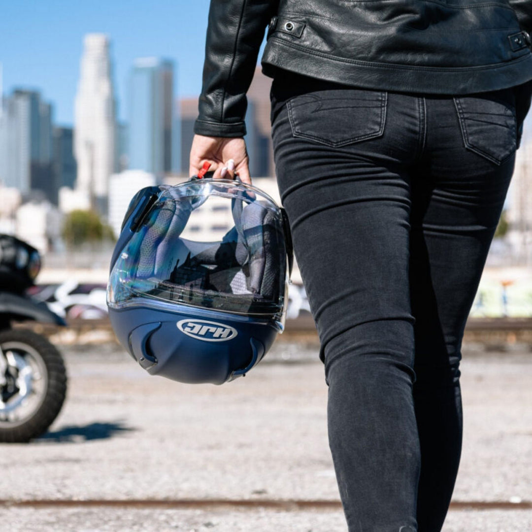 HJC RPHA 31 Solid Helmet Semi-Flat Metallic Blue - Lifestyle Close-Up of Rider Carrying Helmet while walking towards motorcycle