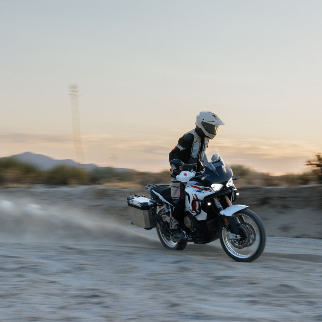 HJC RPHA 60 Solid Helmet Sand Beige - Lifestyle Wide-Shot of Adventure Motorcycle Rider in Helmet speeding across sand track