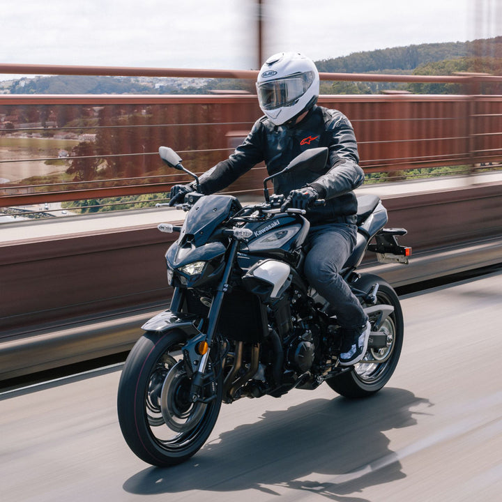 HJC RPHA 72 Solid Helmet White - Lifestyle Shot of Rider in Helmet Riding Motorcycle Across Highway Bridge