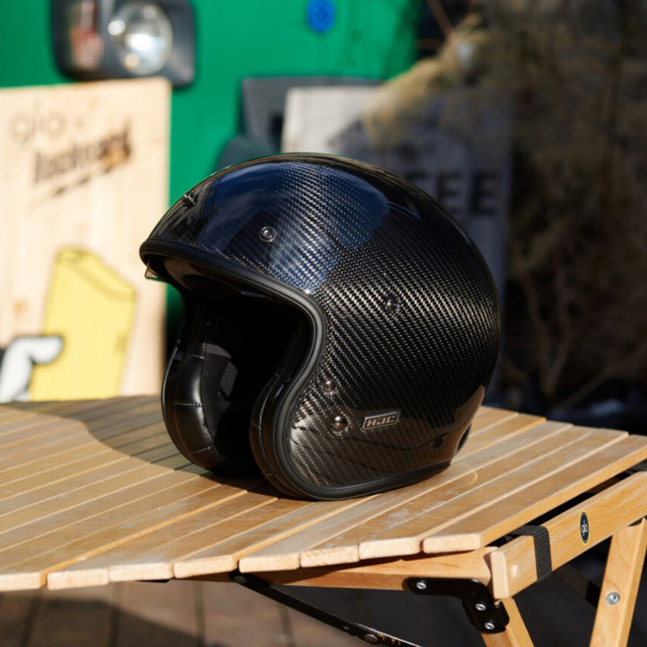 HJC V31 Carbon Helmet Black - Lifestyle Shot of Helmet resting on wooden patio table