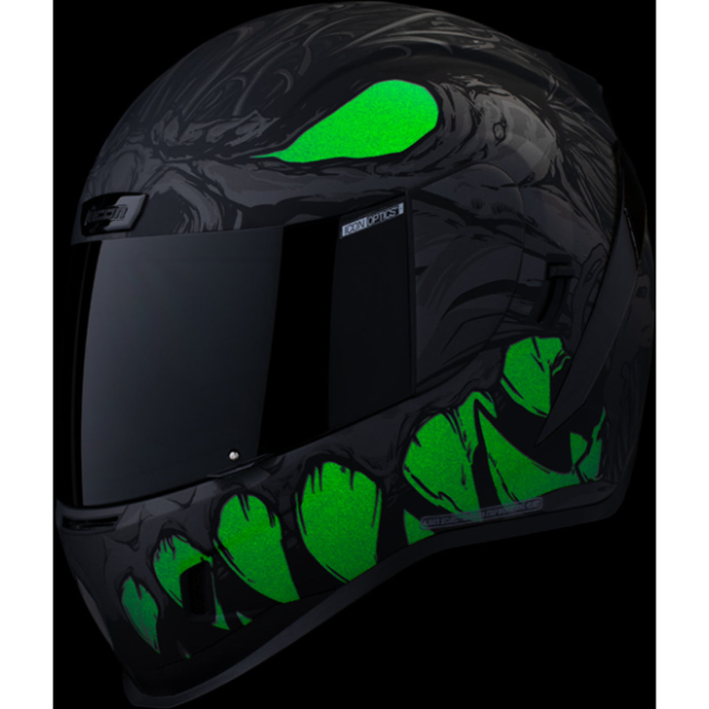 ICON Airform Manik'RR MIPS Helmet Dark Black - Front Left Side View with Dark Studio Background and Glow-in-the-Dark Graphics