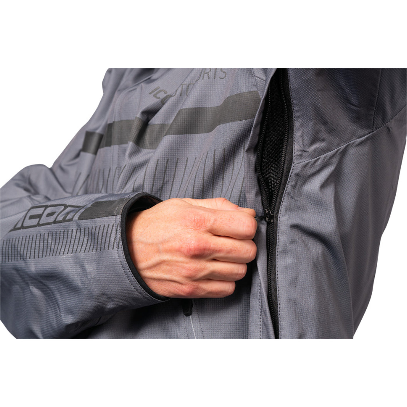 ICON PDX3 Jacket Gray - Close-Up of Model Zipping Armpit Vent